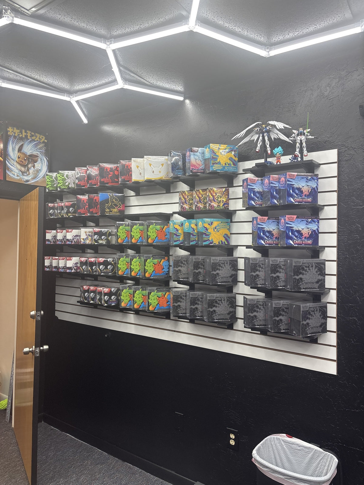 Sealed product wall under the hexagon lights at Deadweight TCG